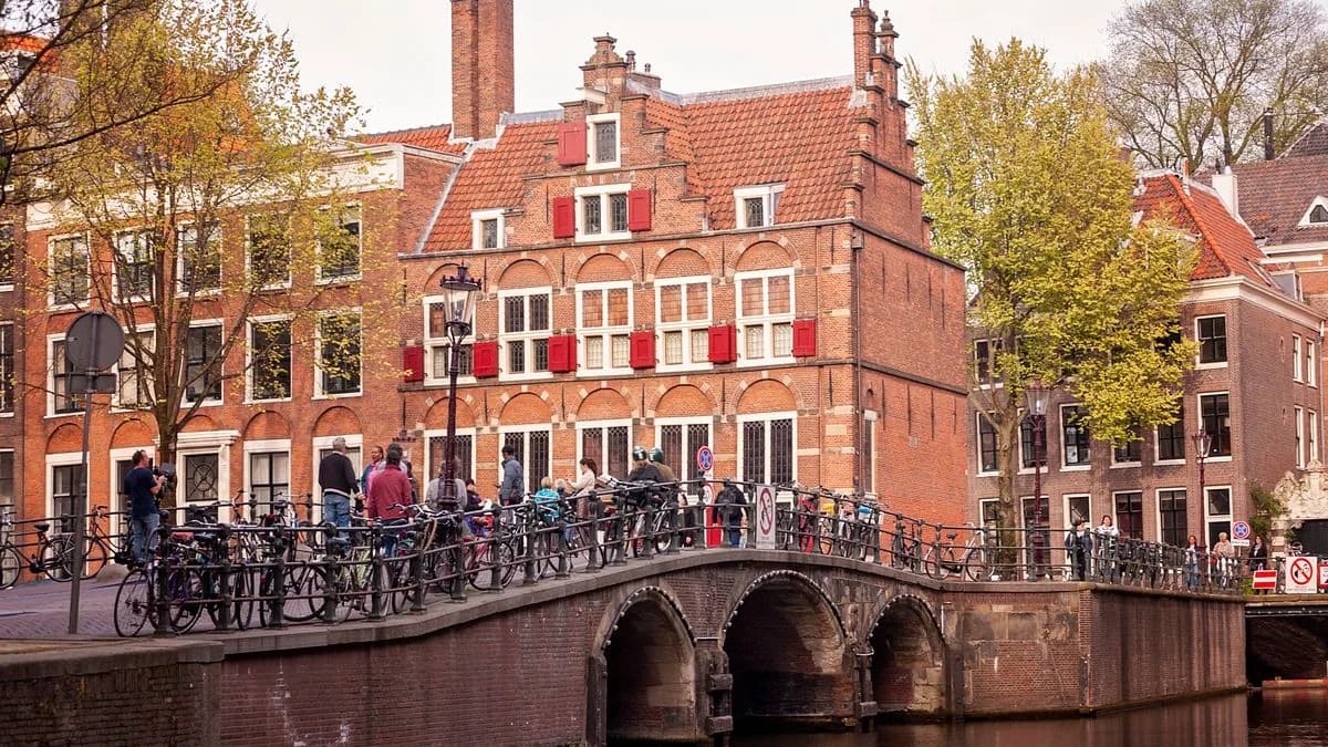 Transferhood — Amsterdam: Your Gateway to the Randstad (a canal, an arched bridge and bicycles in the old city)